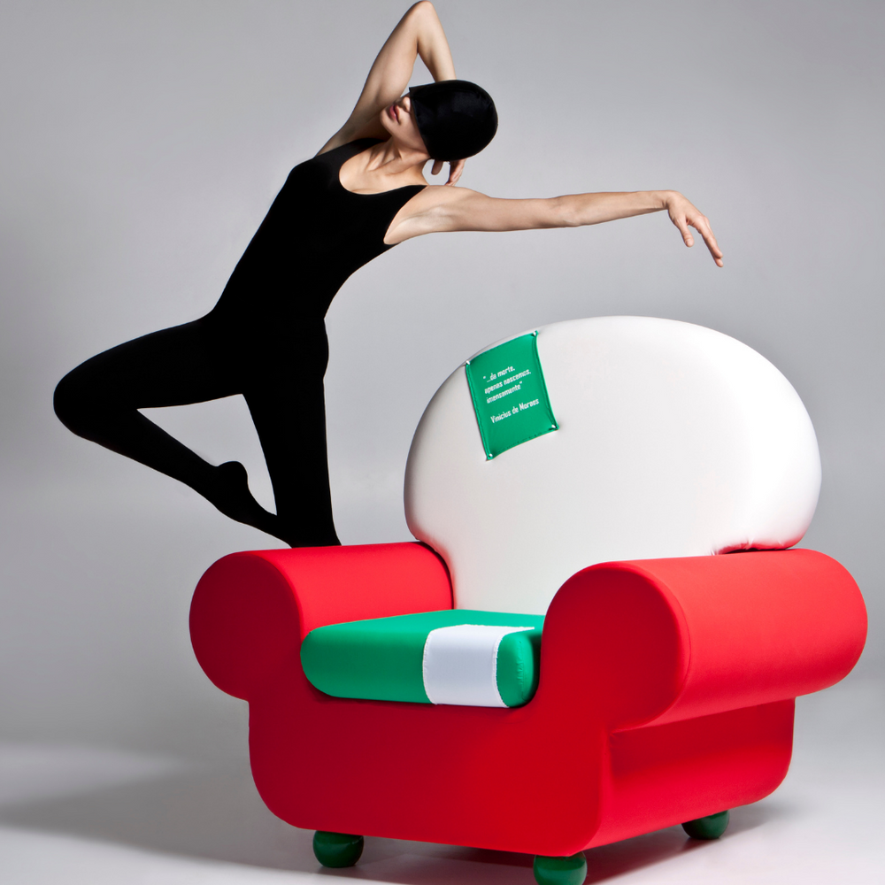 Danzatrice accanto a poltrona Papì rossa e bianca