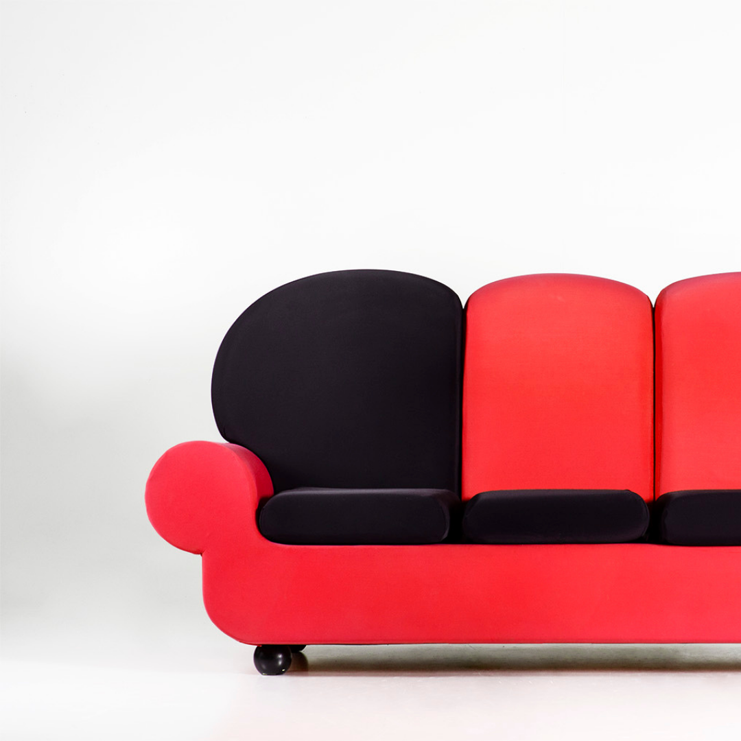 Divano 'Papì colors 3 posti' di Gugliermetto, rossonera con seduta nera su sfondo omogeneo per interni moderni e stilosi.