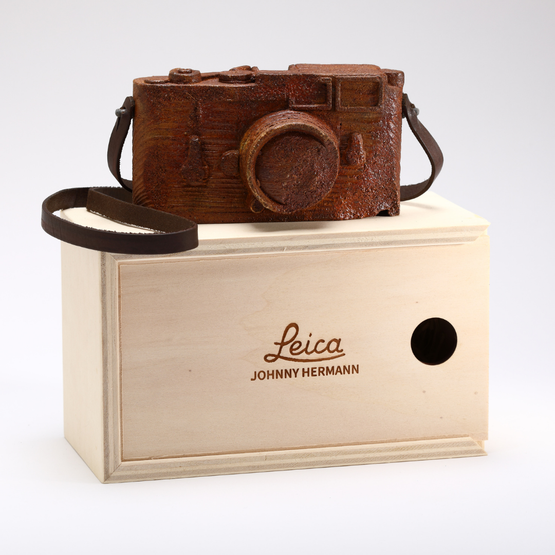 Scultura in legno marrone di macchina fotografica Leica su scatola