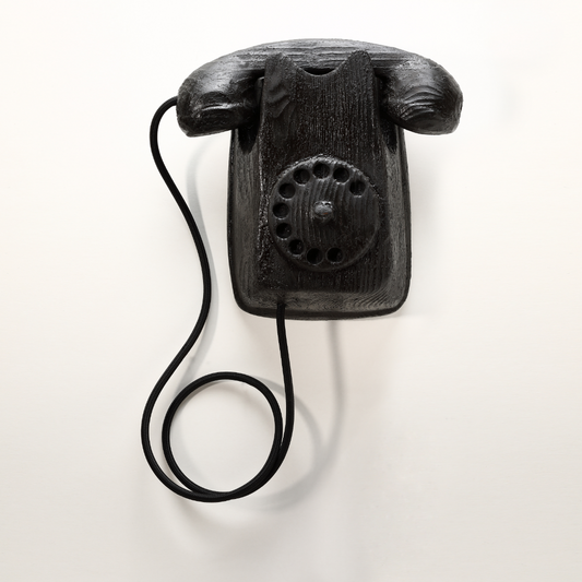 Scultura artistica 'Duplex' di Johnny Hermann, rappresentante un telefono in legno nero, evocando eleganza e nostalgia d'altri tempi.