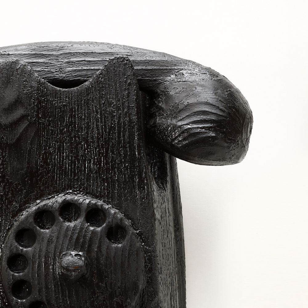 Dettaglio scultura telefono in legno nero di Johnny Hermann