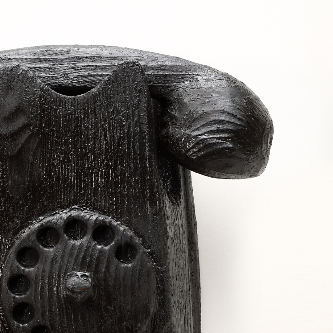 Dettaglio scultura telefono in legno nero di Johnny Hermann