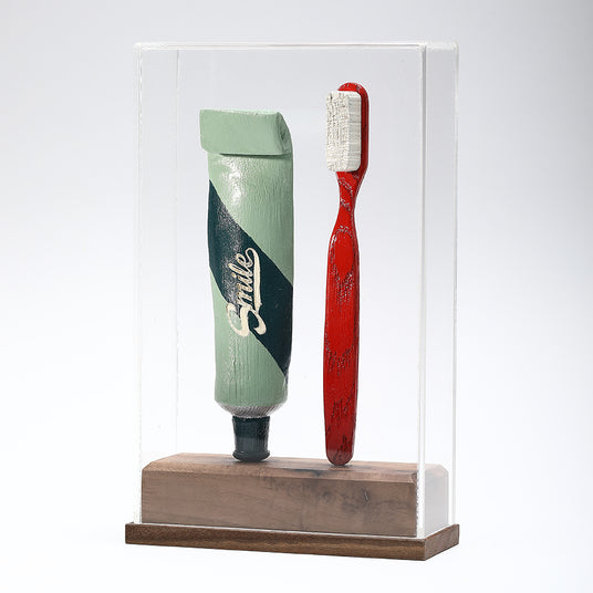 Opera di Johnny Hermann in Legno che ritrae uno Spazzolino da denti e un tubetto di dentifricio