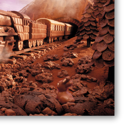 Dettaglio quadro Opera artistica di Carl Warner che raffigura un treno fatto di cioccolato in viaggio su binari tra paesaggi dolciari, evocando meraviglia e piacere.