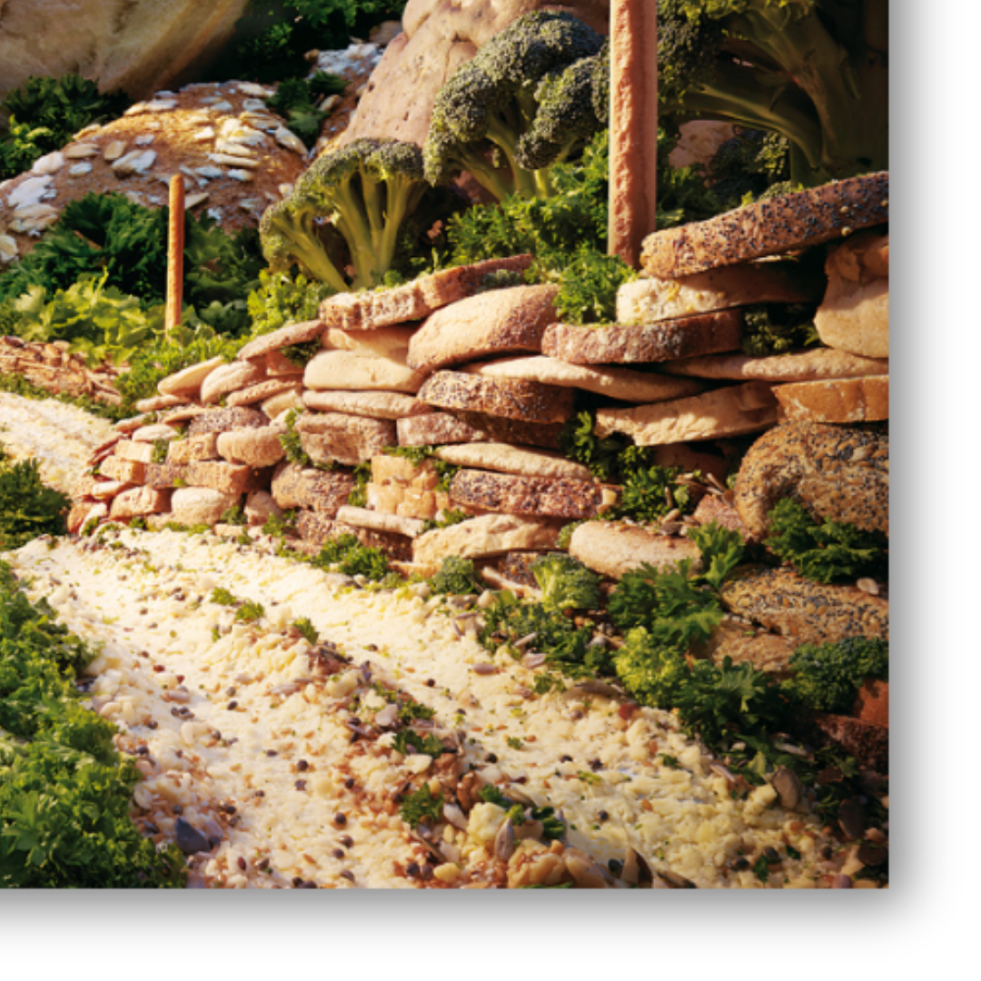 Dettaglio Quadro su tela 'Bread & Cheese' di Carl Warner, un paesaggio dove pane e formaggio creano una scena rurale idilliaca, perfetta per stimolare l'appetito di fantasia e gioco nella cameretta 🧀🥖👶