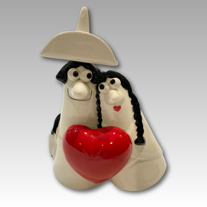 Carmencita e Caballero, statuetta in ceramica di coppia abbracciata con un grande cuore rosso, simbolo di amore e affetto.