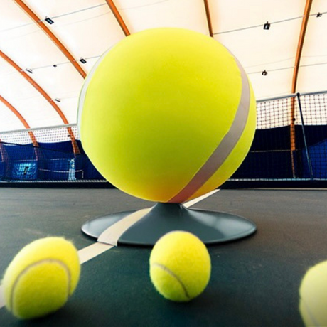 Pouf a forma di pallina da tennis su campo da tennis