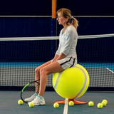 Donna seduta su pouf a forma di pallina da tennis su campo