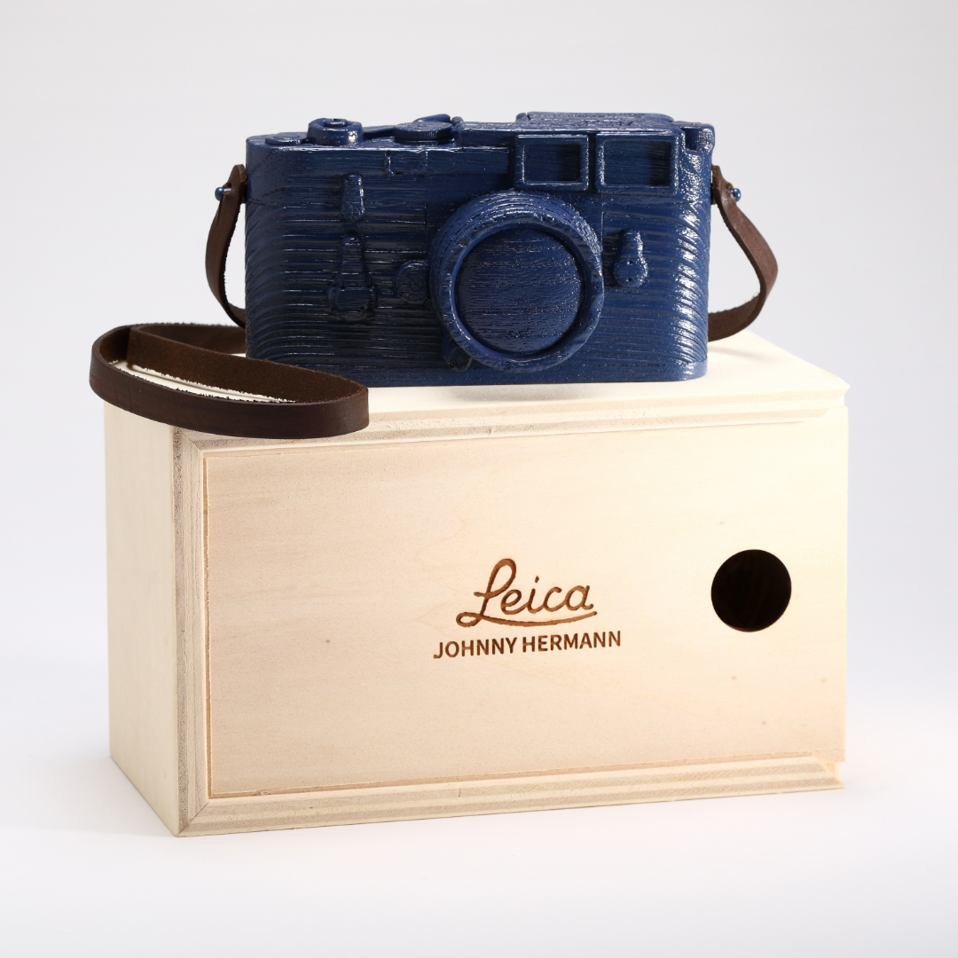Opera 'Leica Color' di Johnny Hermann, scultura in legno raffigurante una fotocamera Leica in varianti di colore, arte e design uniti. Questa color Blu.