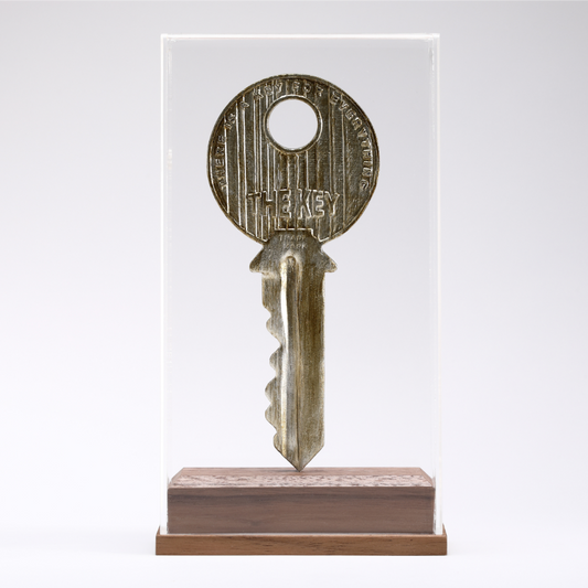 Scultura 'The Key' di Johnny Hermann, rappresentando una chiave in bronzo che eleva il quotidiano a arte.
